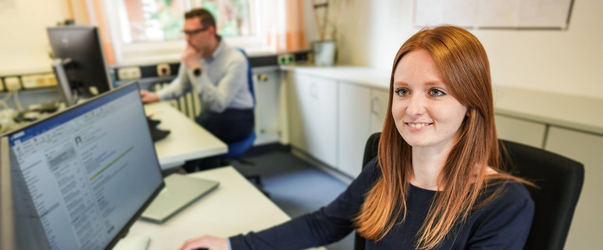Rothaarige Frau im Büro des Geschäftsbereiches IT