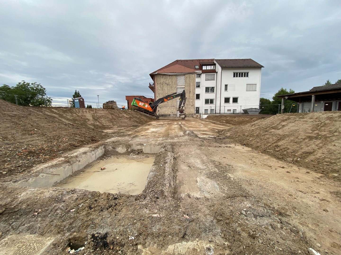 Blick auf das Abbruchgelände mit dem erhaltenen Gebäudeteil im Hintergrund.